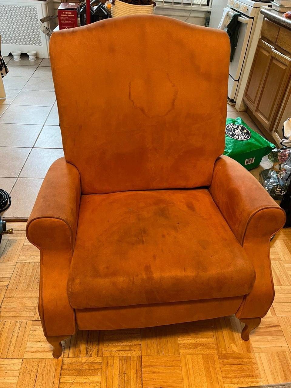 Orange microfiber recliner with watermarks and grime before upholstery cleaning