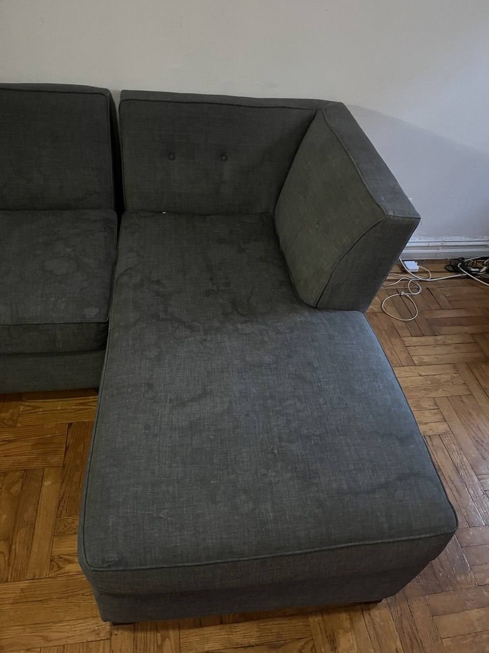 Grey chaise sectional with dried spill marks before upholstery cleaning
