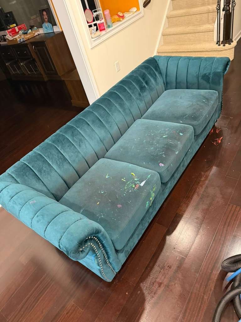 Teal tufted sofa with visible stains and discoloration before cleaning