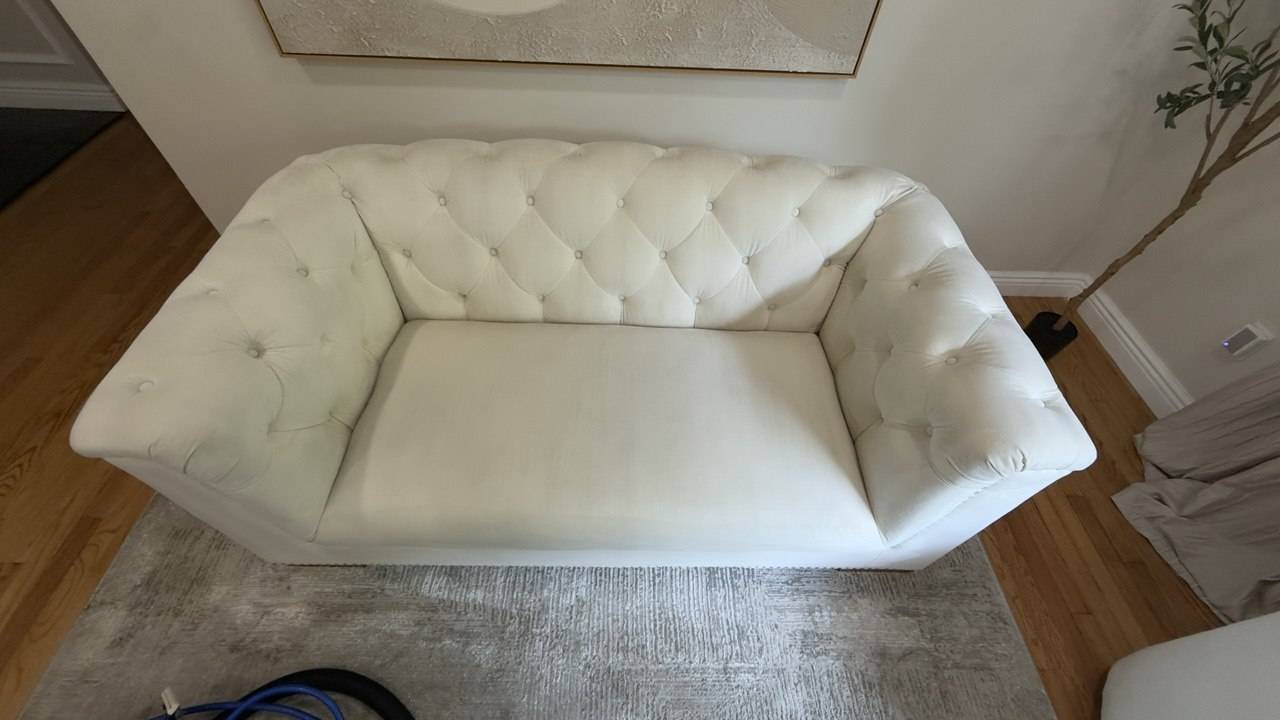 White sofa with body oils and gray shading before couch cleaning