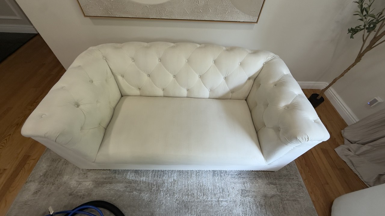White tufted sofa with shading and discoloration before cleaning